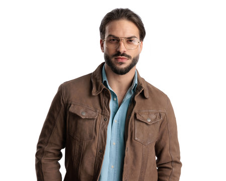 attractive casual man with glasses looking forward and posing in front of white backgroundの写真素材