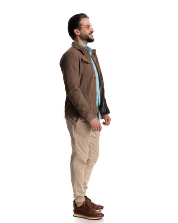 side view of happy casual man with glasses looking to side and smiling in front of white backgroundの写真素材