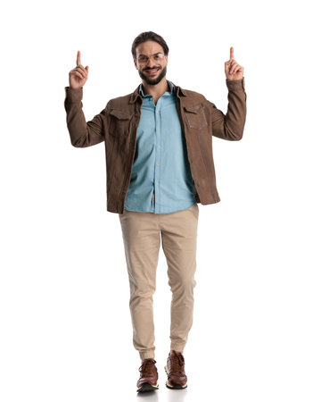 handsome casual guy with glasses pointing finger up and smiling, walking and posing on white backgroundの写真素材