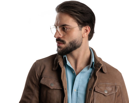 sexy bearded guy with glasses looking to side and posing in a confident way in front of white backgroundの写真素材