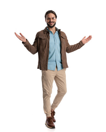 sexy young man with glasses smiling, opening arms and inviting while walking in front of white backgroundの写真素材