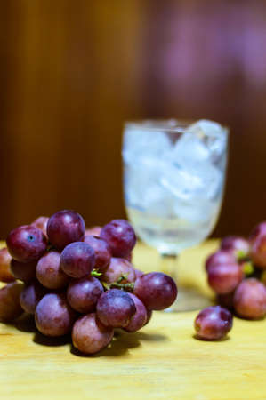 Red  grapes and glass  on a wooden tableの写真素材