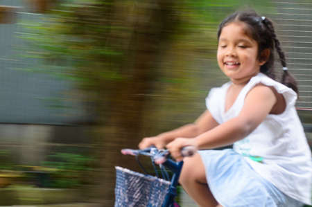 Daughter with spinning bicycle with the speedの写真素材