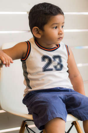 Son on white chair in sunny dayの写真素材
