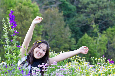 Asian woman relaxing in the flowers gardenの写真素材
