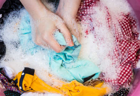 Women washing clothes in the enameled bowlの写真素材