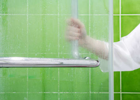 Young woman open glass partition in the bathroomの写真素材