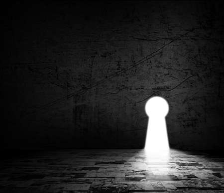 Solution concepts of grunge wall in dark room with light outside the keyhole doorの写真素材