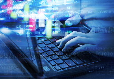 Business woman are checking stock market graph by using laptopの写真素材