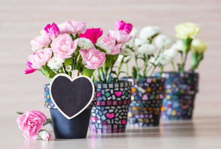 Flowers in the pot with blank wooden heart clothes pinの写真素材