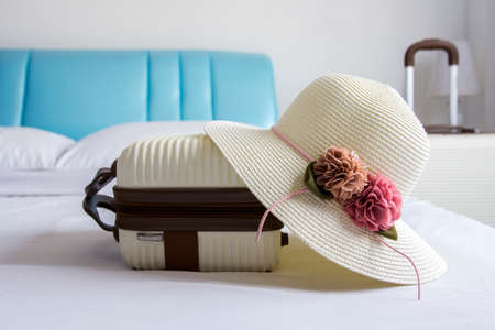 Hat and luggage on bed in the bedroomの写真素材