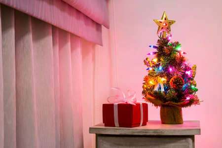 Colorful small christmas tree on cabinet in the bedroomの写真素材