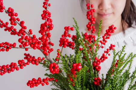 Cute woman holding ilex verticillata or winterberry for christmas decorationの写真素材