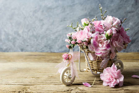 Pink carnation in bicycle on old woodの写真素材