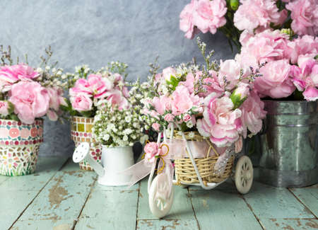 Pink carnation in basket bicycle on old woodの写真素材
