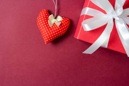 Red fabric heart and gift box on paper backgroundの写真素材