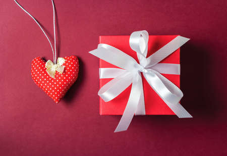 Red fabric heart and gift box on paper backgroundの写真素材