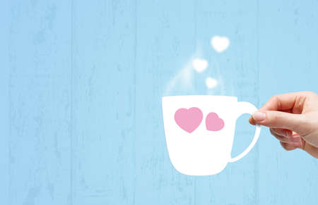 Young woman hand holding white paper cup with smoke heart shape for valentines dayの写真素材