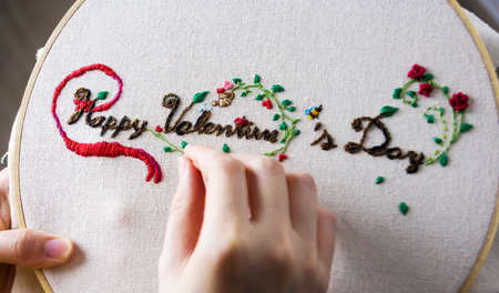 Love concept of young woman hands are embroidered happy valentines dayの写真素材