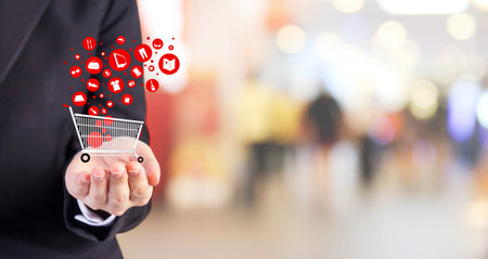 Online shopping concept of young business woman hand holding shopping cart with object icon designの写真素材