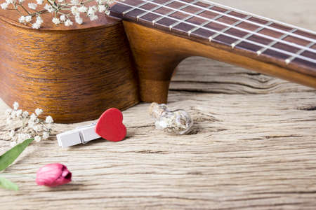 Music lover concept of ukulele and red heart clothes peg on old woodの写真素材