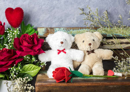 Love concept of couple teddy bear with red heart and rose on old chair for valentines day and weddingの写真素材
