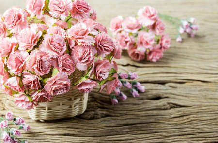 Paper pink carnation flowers on old woodの写真素材
