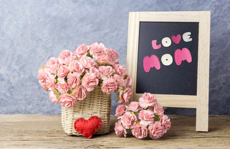 Mothers day concept of paper carnation flowers with love mom on black boardの写真素材