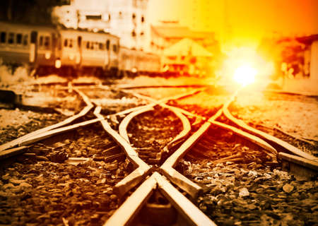 Railroad track in train station at sunsetの写真素材