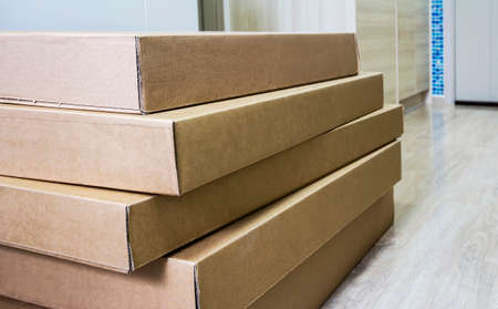 Pile of brown corrugated furniture box on laminate floor in living room at new condominiumの写真素材