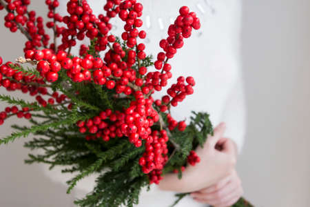 Woman hands holding ilex verticillata or winterberry for christmas decorationの写真素材