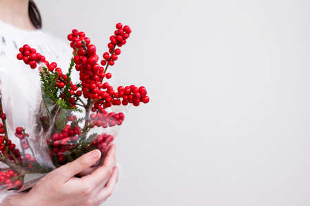 Woman hands holding ilex verticillata or winterberry for christmas decorationの写真素材