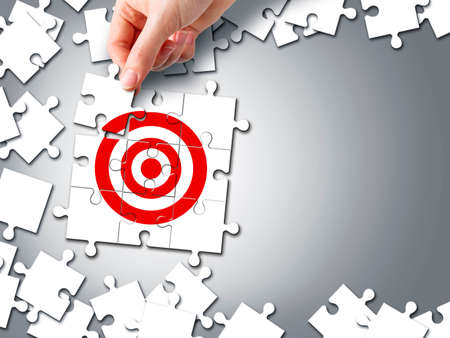 Target business concept of hand holding jigsaw puzzleの写真素材