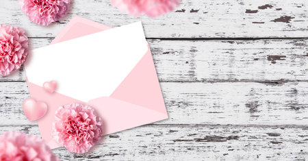 White paper in pink envelope and heart with carnation flowers on wood texture background with copy...