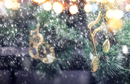 Music note decoration on christmas tree with snow falling in the winterの写真素材