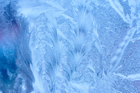 Frozen winter abstract background with a pattern on the window glassの写真素材