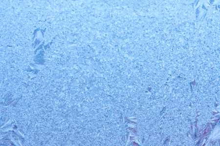 Frozen winter abstract background with a pattern on the window glassの写真素材