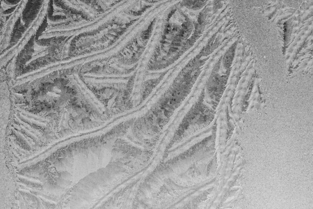 Black and white ice patterns on the glass. Monochrome winter background with a frosty textureの写真素材