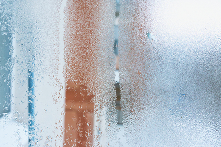 Close up detail of moisture condensation problem, hot water vapor condensed on the cold window glass, macroの写真素材