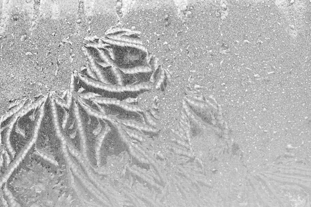 Black and white ice patterns on the glass. Monochrome winter background with a frosty textureの写真素材