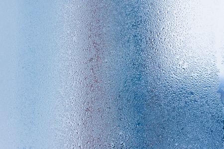 Hot water vapor condensed on the cold window glass, macro texture or backgroundの写真素材