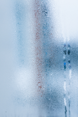 Background of natural water condensation, window glass with high air humidity, large drops drip. Collecting and streaming downの写真素材