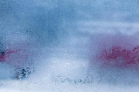 Hot water vapor condensed on the cold window glass, macro texture or backgroundの写真素材