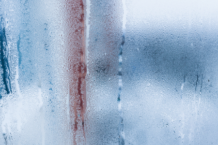 Background of natural water condensation, window glass with high air humidity, large drops drip. Collecting and streaming downの写真素材
