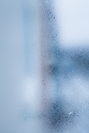 Blurry abstract background of foggy condensation on window glass natural surface. High humidity with formation of water dropletsの写真素材