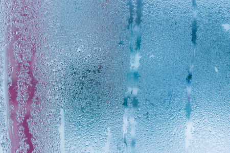 Background of natural water condensation, window glass with high air humidity, large drops drip. Collecting and streaming downの写真素材