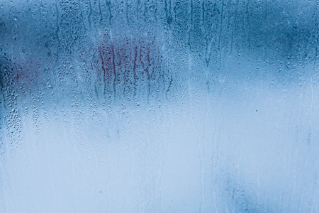 Background of natural water condensation, window glass with high air humidity, large drops drip. Collecting and streaming downの写真素材