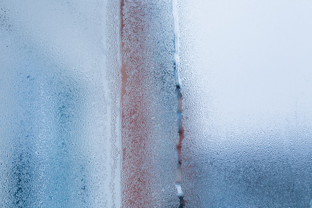 Blurry abstract background of foggy condensation on window glass natural surface. High humidity with formation of water dropletsの写真素材