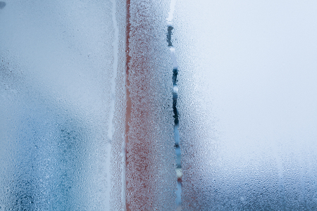 Blurry abstract background of foggy condensation on window glass natural surface. High humidity with formation of water dropletsの写真素材