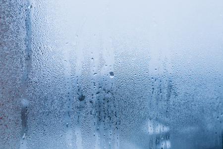 Background of natural water condensation, window glass with high air humidity, large drops drip. Collecting and streaming downの写真素材